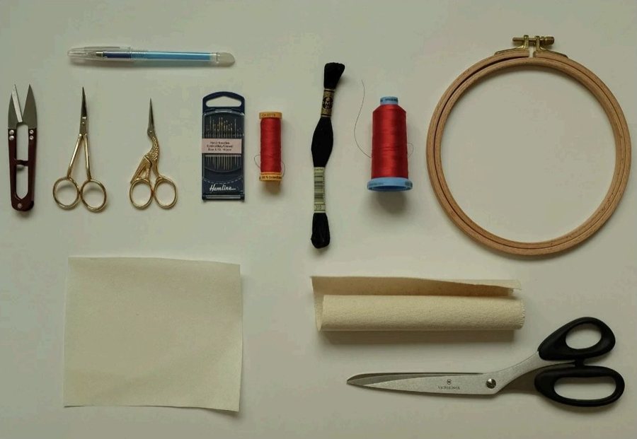 The whole hand embroidery kit laid out flat: hoop, needles, threads, scissors, fabric and a water-soluble pen